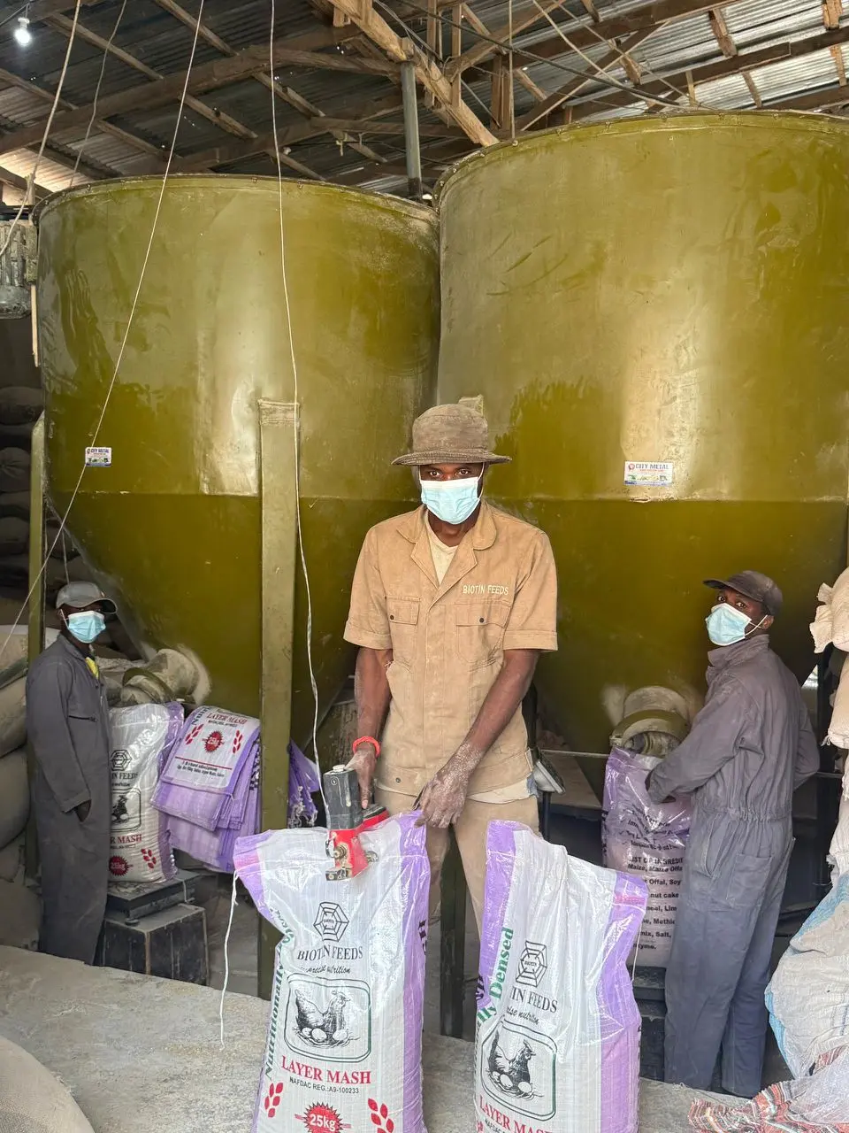 Biotin Feeds workers sealing Layer Mash bags during production