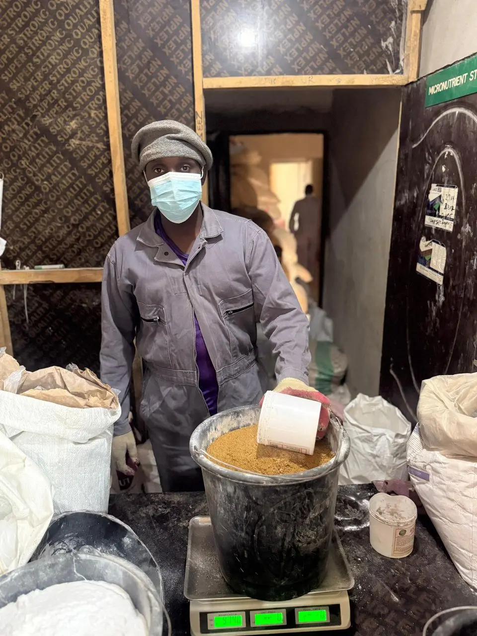 Worker carefully measuring feed ingredients on a digital scale